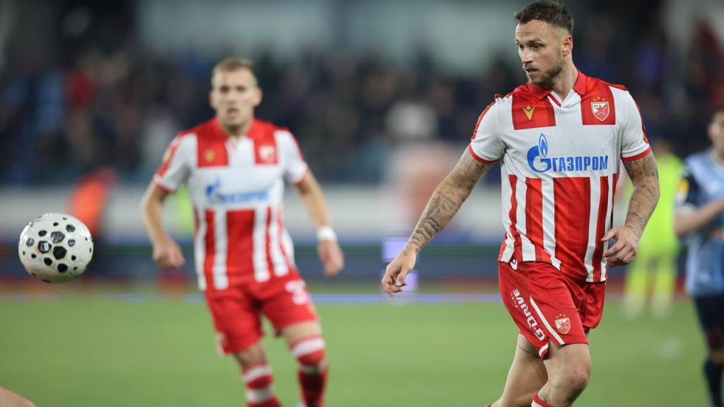 Dvojica fudbalera Crvene zvezde trče u crveno-belim dresovima