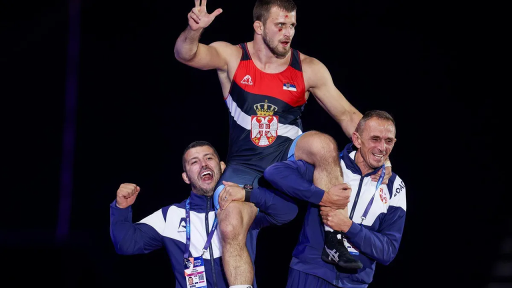 Aleksandar Komarov slavi rvačku pobedu sa trenerima