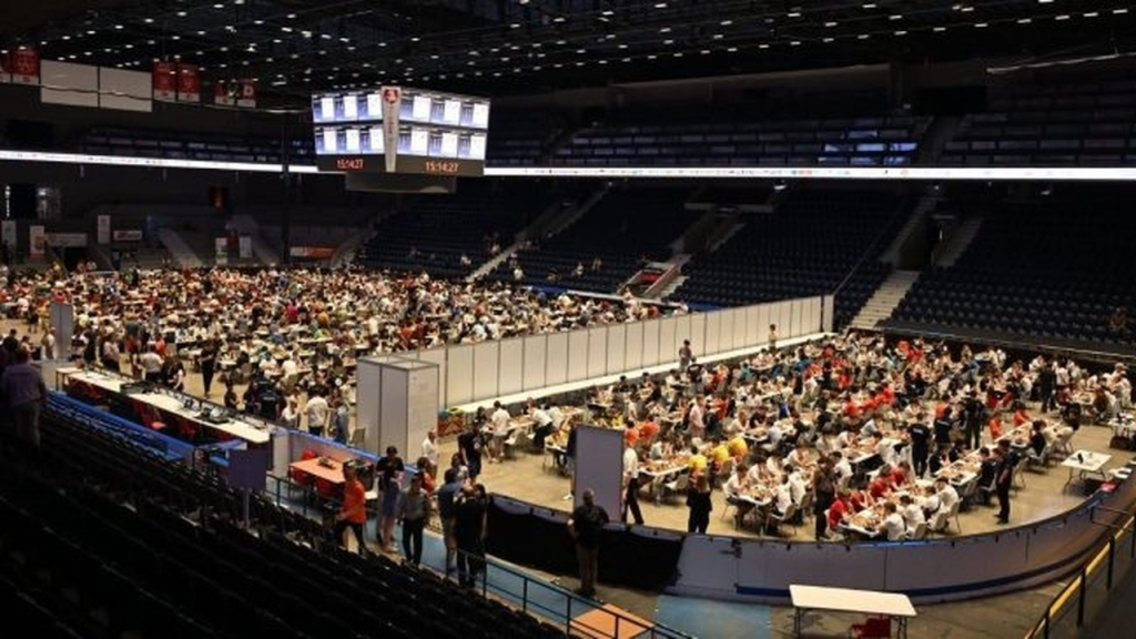 Young chess players compete in a large tournament hall